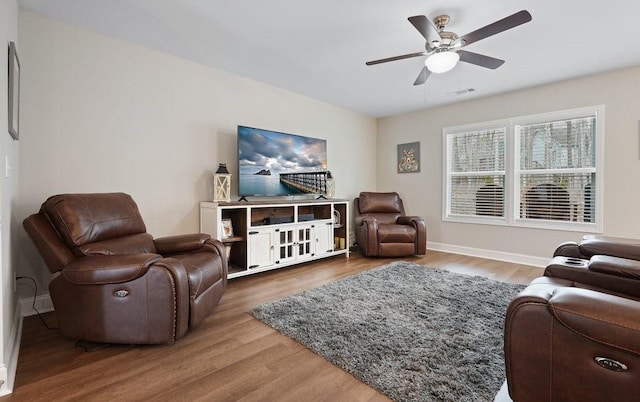 living room with baseboards, ceiling fan, visible vents, and wood finished floors