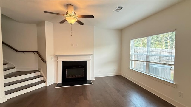 32 S Auburn Landing Pl, Auburn, GA 30011 - unfurnished living room with ceiling fan, wood finished floors, a fireplace with raised hearth, baseboards, and stairway