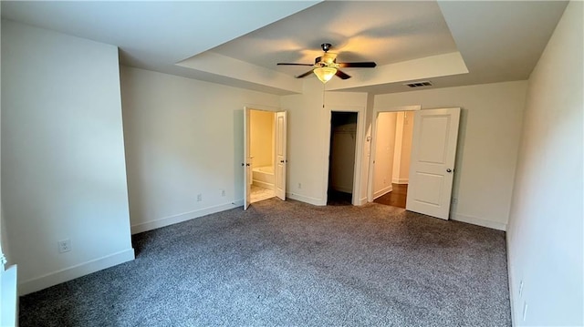 32 S Auburn Landing Pl, Auburn, GA 30011 - unfurnished bedroom with a tray ceiling, dark carpet, baseboards, and ceiling fan