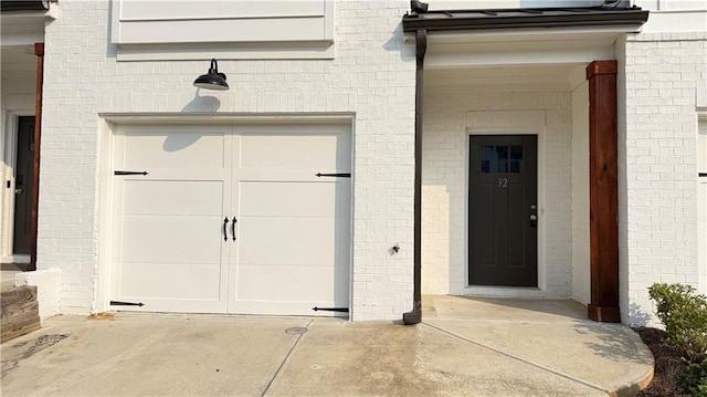 32 S Auburn Landing Pl, Auburn, GA 30011 - view of exterior entry with concrete driveway, a garage, and brick siding