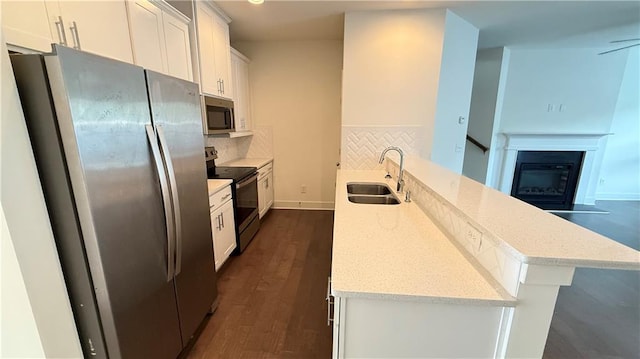 32 S Auburn Landing Pl, Auburn, GA 30011 - kitchen with stainless steel appliances, a sink, dark wood-style floors, white cabinets, and tasteful backsplash