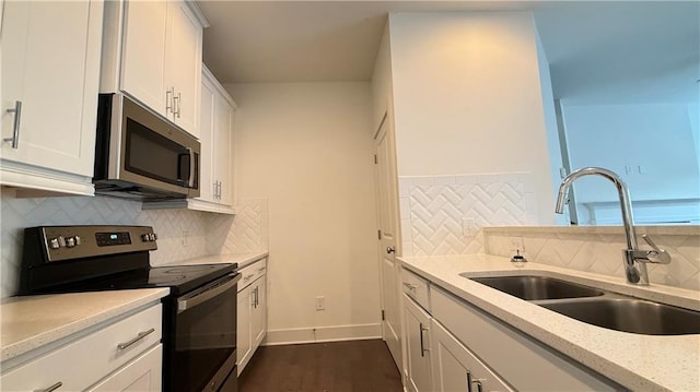 32 S Auburn Landing Pl, Auburn, GA 30011 - kitchen featuring range with electric stovetop, a sink, stainless steel microwave, backsplash, and white cabinets