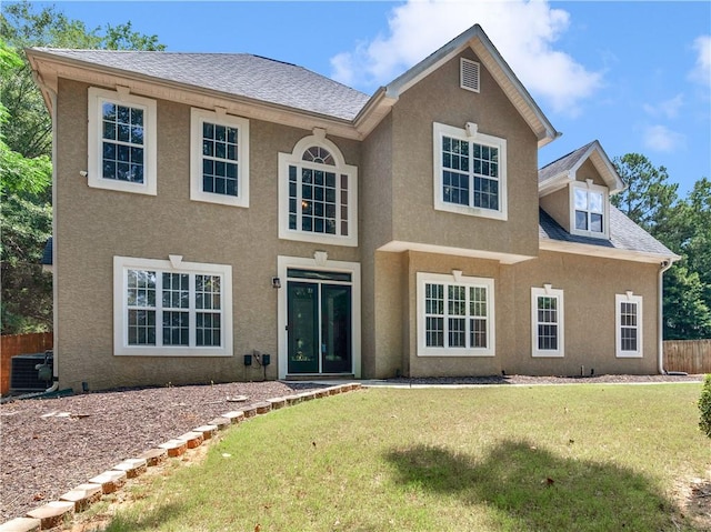 view of front of house with central AC unit and a front lawn