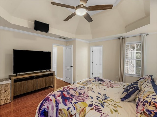 bedroom featuring a raised ceiling, ornamental molding, and dark wood-type flooring