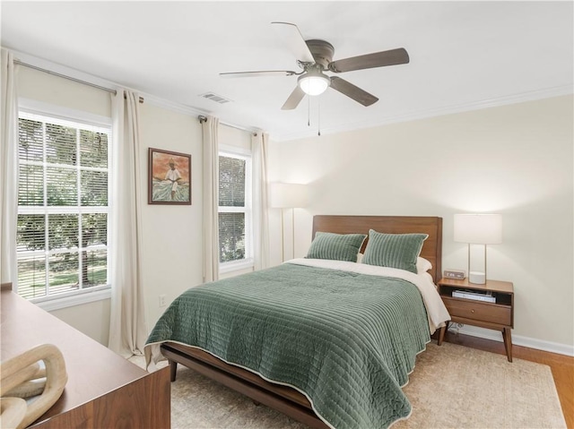 bedroom with ornamental molding, light hardwood / wood-style floors, and ceiling fan