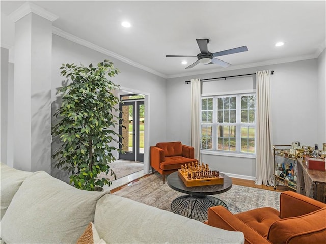 living room with hardwood / wood-style floors, a wealth of natural light, and ornamental molding