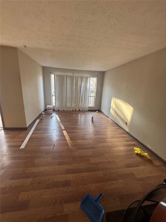 unfurnished room featuring dark hardwood / wood-style floors and a textured ceiling