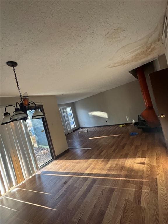 interior space featuring dark wood-type flooring, a chandelier, and a textured ceiling