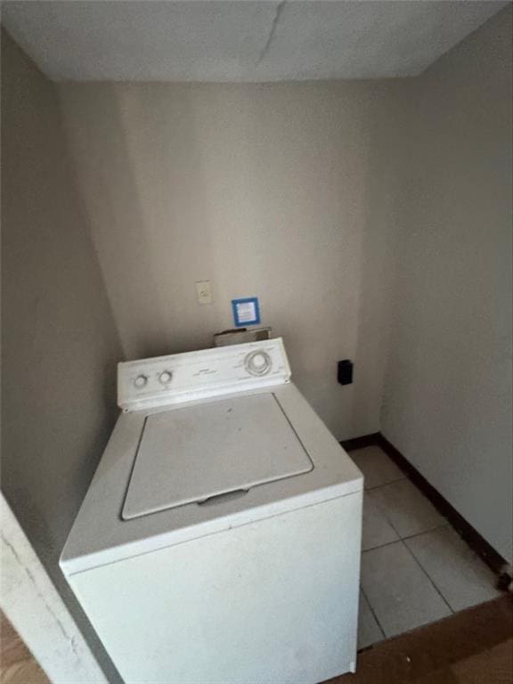 washroom with washer / clothes dryer and light tile patterned flooring