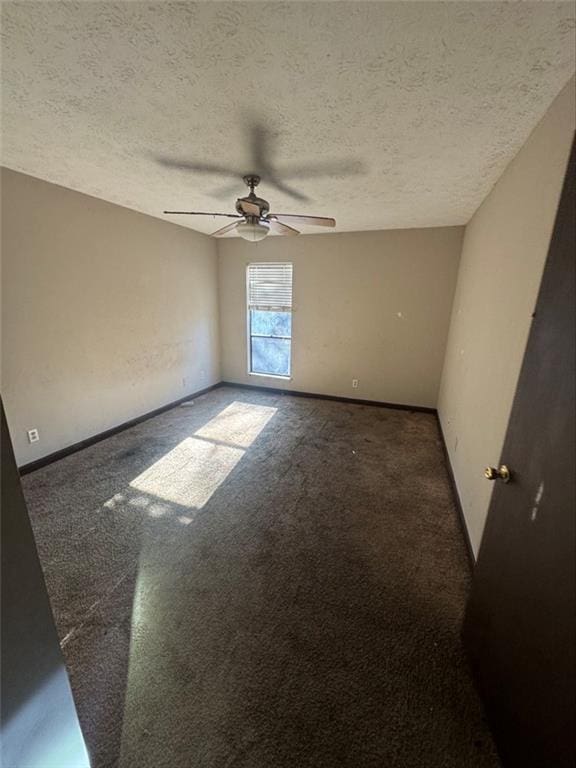 carpeted empty room with ceiling fan and a textured ceiling