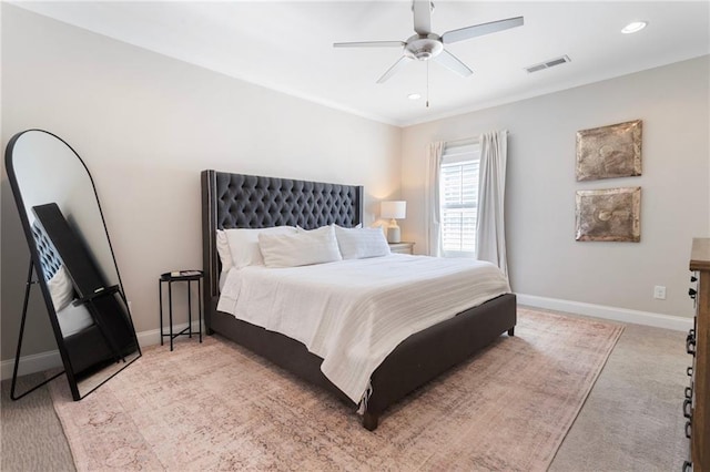 bedroom featuring a ceiling fan, visible vents, light colored carpet, and baseboards