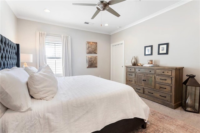 bedroom with ornamental molding, visible vents, ceiling fan, and light carpet