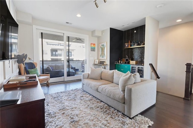 living room with visible vents, a bar, wood finished floors, and a healthy amount of sunlight