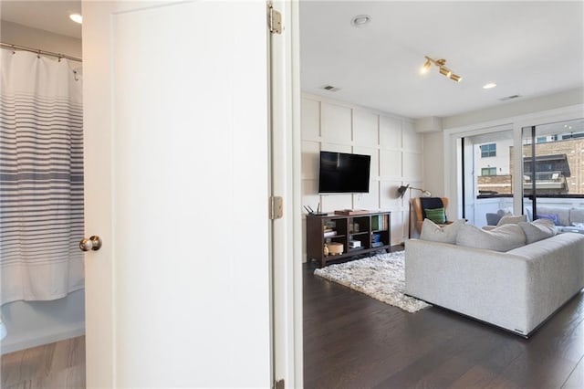 living area with recessed lighting, visible vents, and wood finished floors