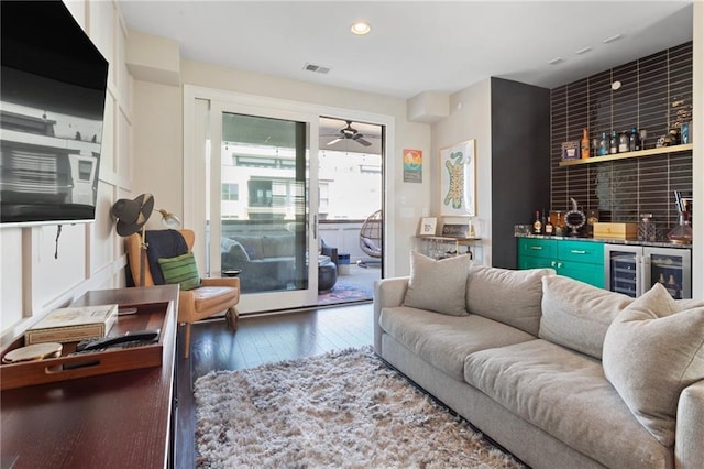 living room featuring recessed lighting, ceiling fan, wet bar, visible vents, and hardwood / wood-style flooring