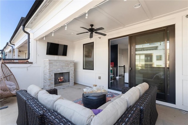 view of patio with ceiling fan and an outdoor living space with a fireplace