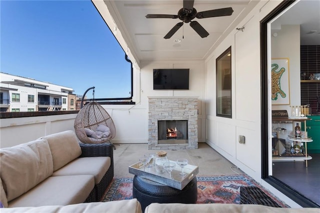 view of patio with ceiling fan and an outdoor living space with a fireplace