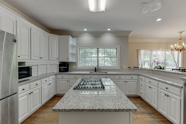 kitchen with stainless steel appliances, a center island, open shelves, and wood finished floors