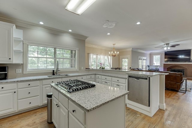 kitchen featuring stainless steel appliances, light wood-type flooring, a healthy amount of sunlight, and a sink