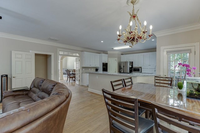 dining area with arched walkways, crown molding, visible vents, a chandelier, and light wood-type flooring