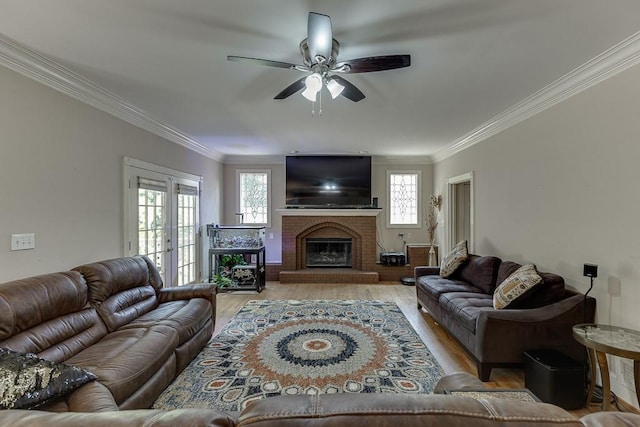 living area featuring light wood finished floors, a brick fireplace, ornamental molding, and french doors