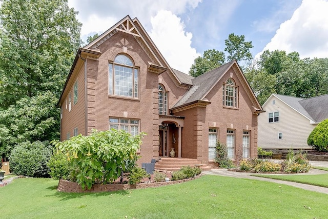 traditional-style house with a front lawn and brick siding