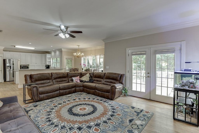 living room with ornamental molding, french doors, plenty of natural light, and light wood-style flooring