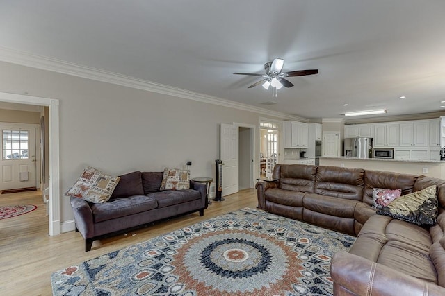 living area featuring ornamental molding, light wood-type flooring, and ceiling fan