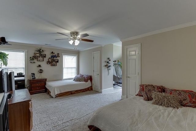 carpeted bedroom with ceiling fan, multiple windows, baseboards, and crown molding