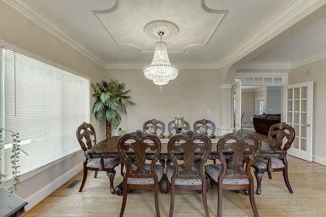 dining room with arched walkways, light wood finished floors, a wealth of natural light, and a notable chandelier