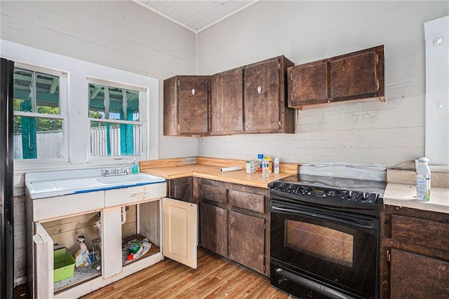 kitchen with black electric range, sink, dark brown cabinetry, and light wood-type flooring