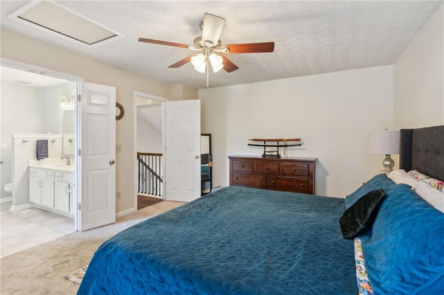 bedroom with light carpet, attic access, baseboards, ceiling fan, and a sink