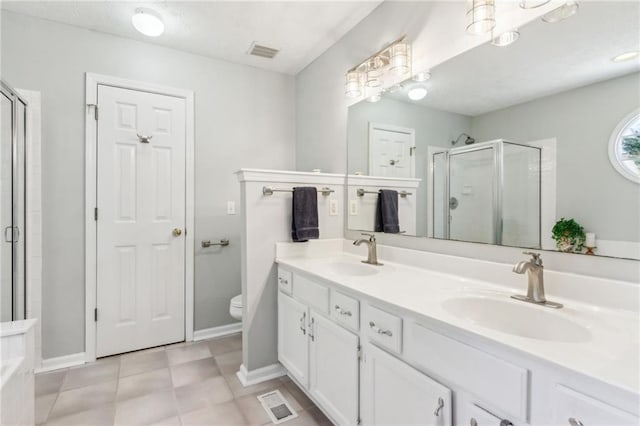 bathroom featuring a stall shower, visible vents, a sink, and double vanity