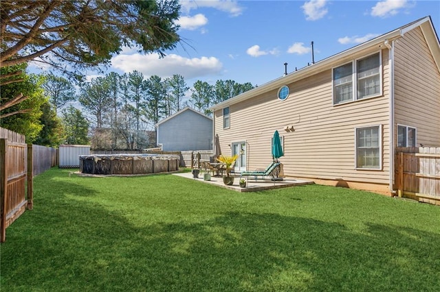 back of property with a fenced in pool, a patio area, a fenced backyard, and a yard