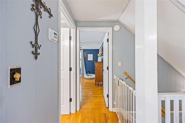 hallway featuring lofted ceiling and light hardwood / wood-style flooring