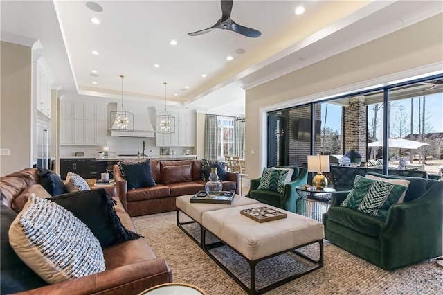 living area with ceiling fan, a raised ceiling, and recessed lighting