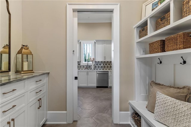 mudroom featuring dark tile patterned floors and baseboards