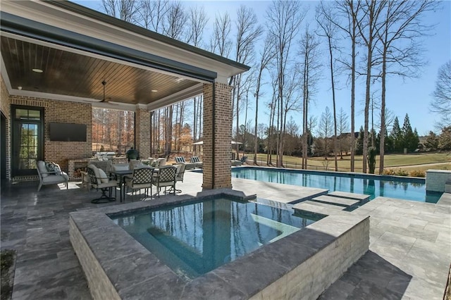 pool featuring a ceiling fan, a patio area, and an in ground hot tub