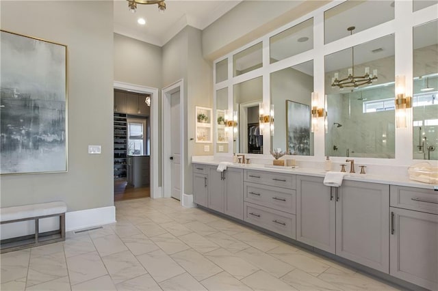 bathroom with marble finish floor, double vanity, a stall shower, a sink, and baseboards