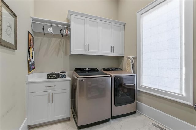 clothes washing area with baseboards, marble finish floor, cabinet space, and washer and dryer