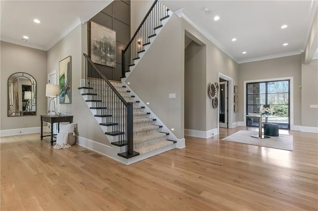 entryway with light wood finished floors, baseboards, crown molding, and recessed lighting