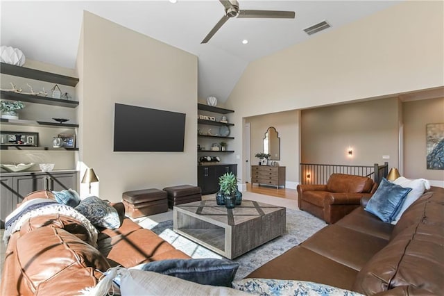 living room with lofted ceiling, ceiling fan, built in shelves, and visible vents