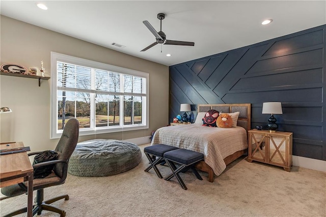 bedroom featuring ceiling fan, recessed lighting, an accent wall, visible vents, and carpet