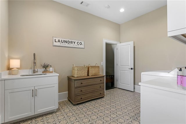 laundry area featuring light floors, cabinet space, visible vents, a sink, and separate washer and dryer