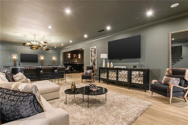 living area with visible vents, stairway, light wood-type flooring, a chandelier, and recessed lighting