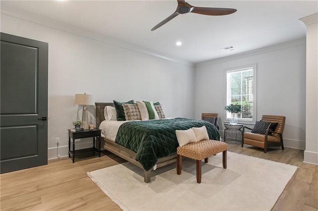 bedroom with baseboards, visible vents, a ceiling fan, crown molding, and light wood-type flooring