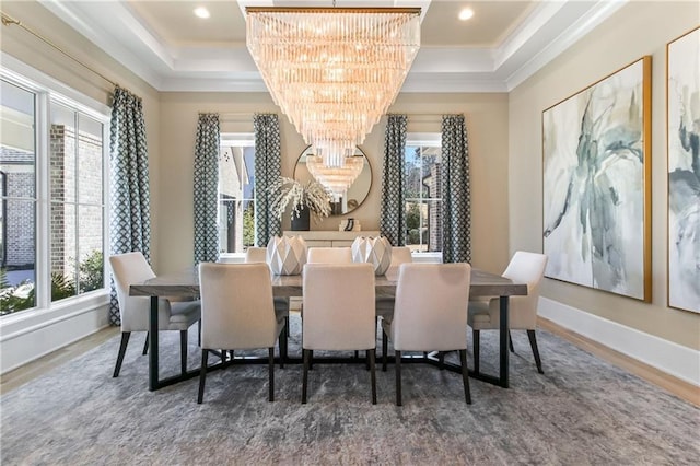 dining room featuring ornamental molding, a tray ceiling, wood finished floors, and an inviting chandelier