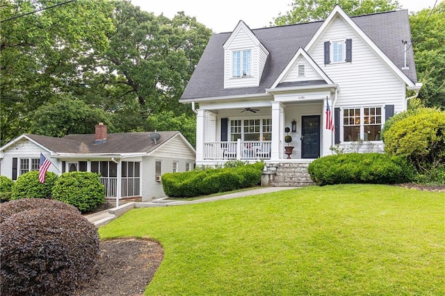 view of front of home with covered porch, a front lawn, ceiling fan, and a sunroom