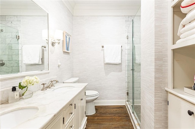 full bath featuring a shower stall, toilet, wood finished floors, double vanity, and crown molding