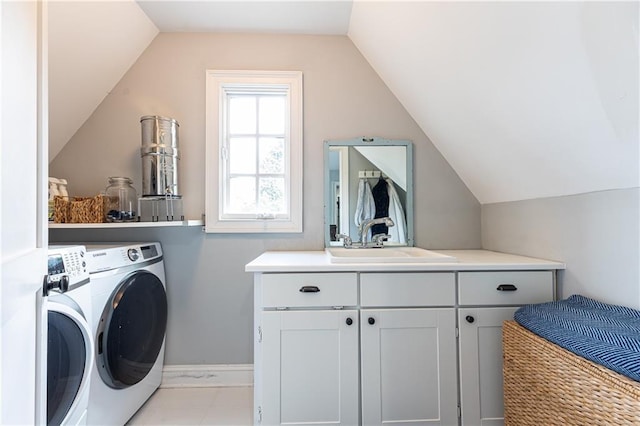 clothes washing area featuring separate washer and dryer, cabinet space, and baseboards